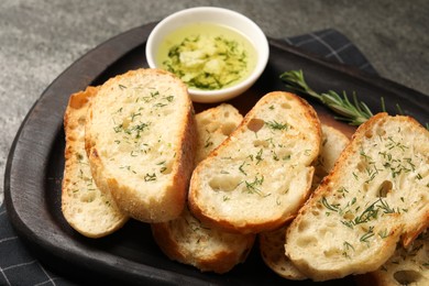 Tasty baguette with garlic and dill served on table, closeup