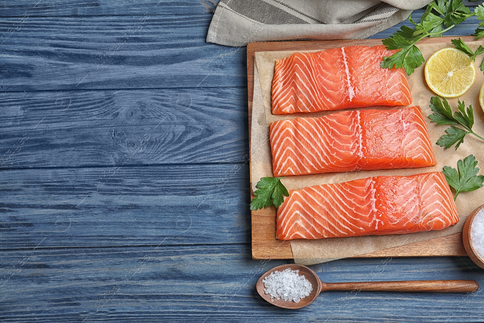 Photo of Flat lay composition with fresh raw salmon on blue wooden table, space for text. Fish delicacy