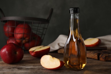 Photo of Composition with bottle of apple vinegar on table. Space for text