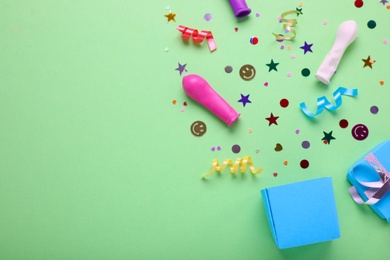 Photo of Flat lay composition with colorful confetti and box on light green background, space for text