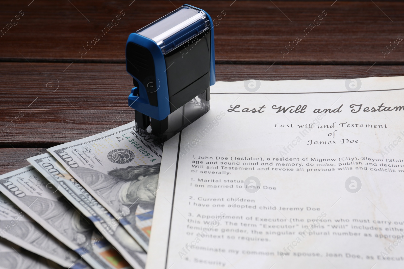 Photo of Last Will and Testament, stamp and dollar bills on wooden table, closeup