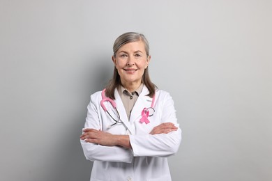 Photo of Mammologist with pink ribbon on gray background. Breast cancer awareness