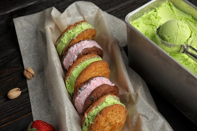 Photo of Different sweet delicious ice cream cookie sandwiches served on table