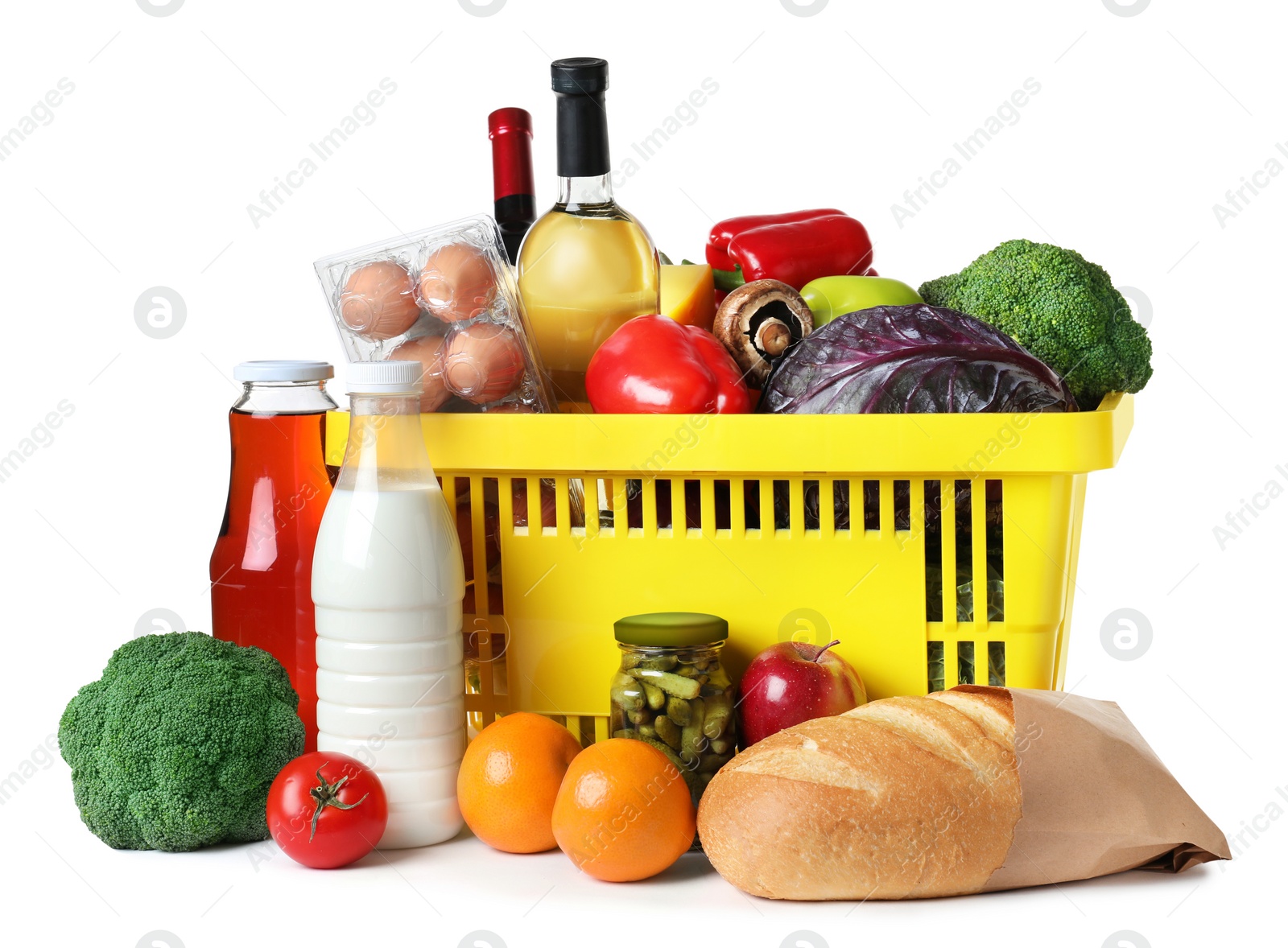 Photo of Shopping basket and grocery products on white background