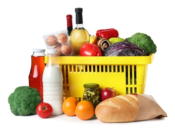 Shopping basket and grocery products on white background