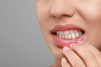 Photo of Woman showing healthy gums on grey background, closeup. Space for text