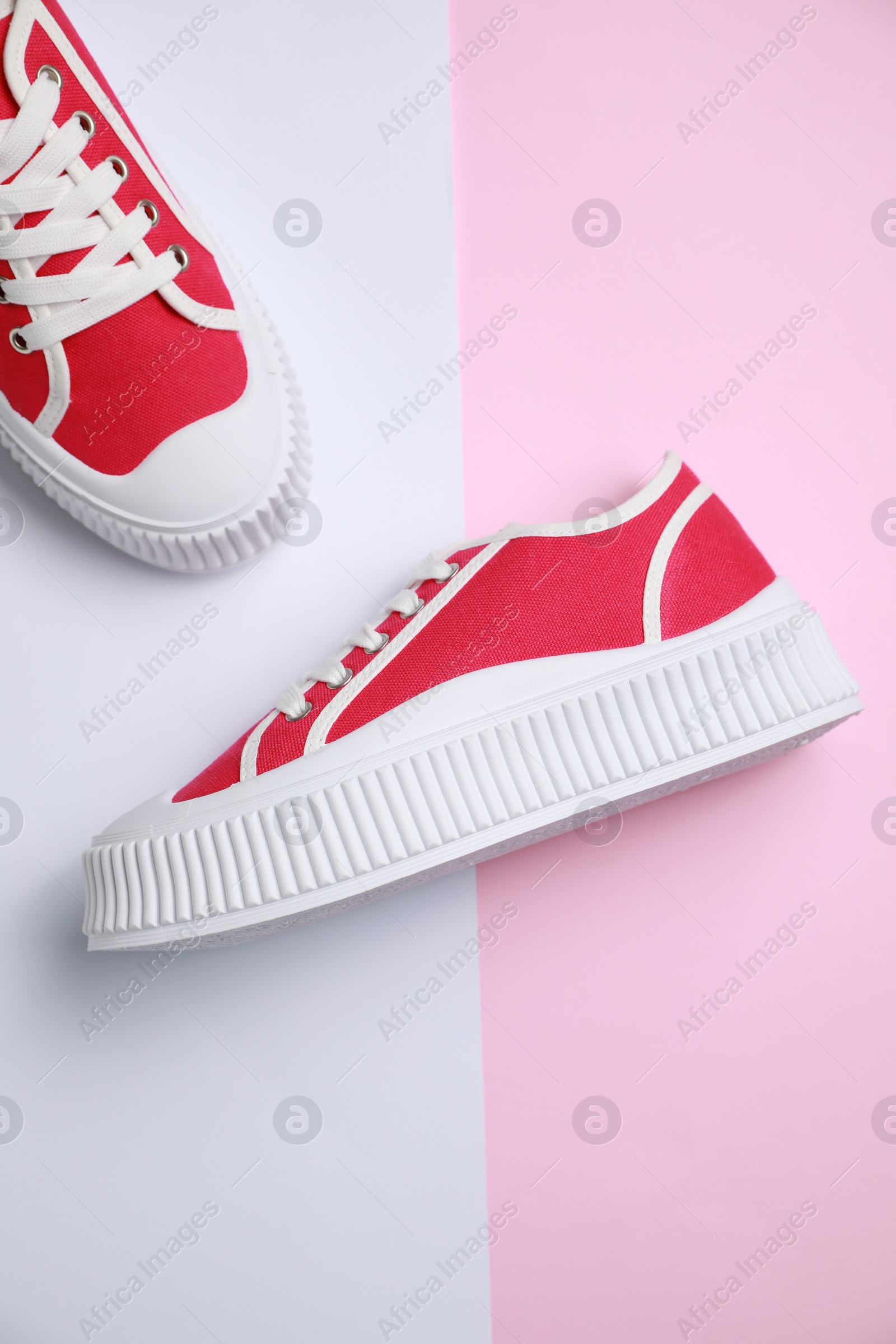 Photo of Pair of red classic old school sneakers on color background, flat lay