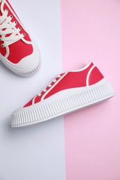 Pair of red classic old school sneakers on color background, flat lay