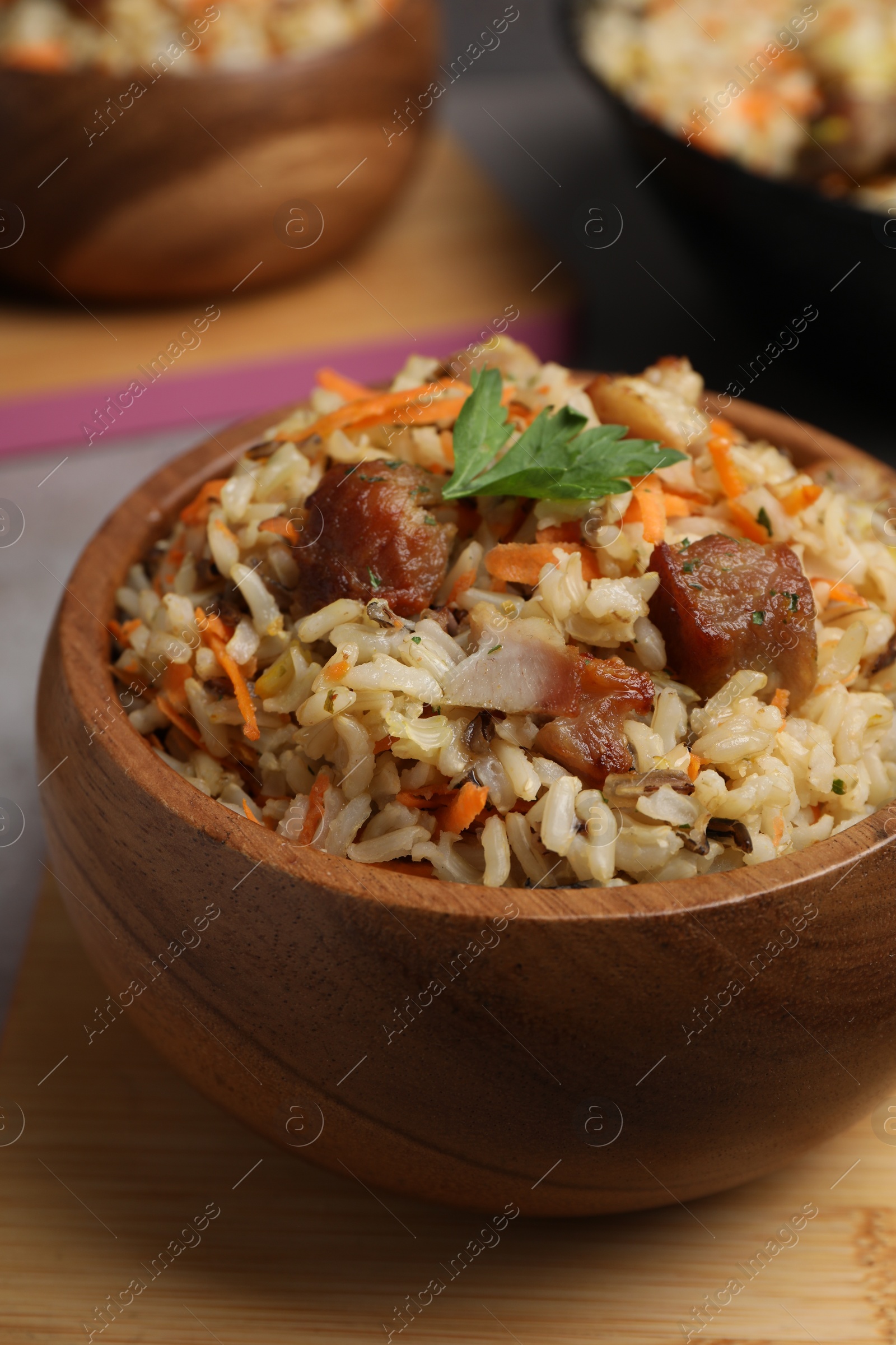 Photo of Delicious pilaf with meat and carrot in bowl on table, closeup