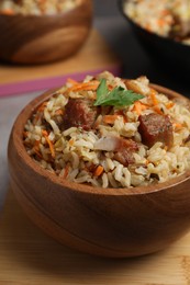 Photo of Delicious pilaf with meat and carrot in bowl on table, closeup
