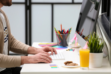 Photo of Male designer working at desk in office, closeup