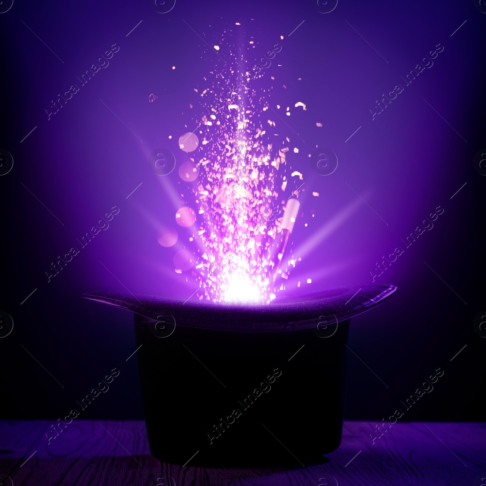 Image of Wizard's hat with magical light and wand in darkness