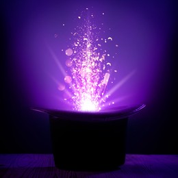 Image of Wizard's hat with magical light and wand in darkness