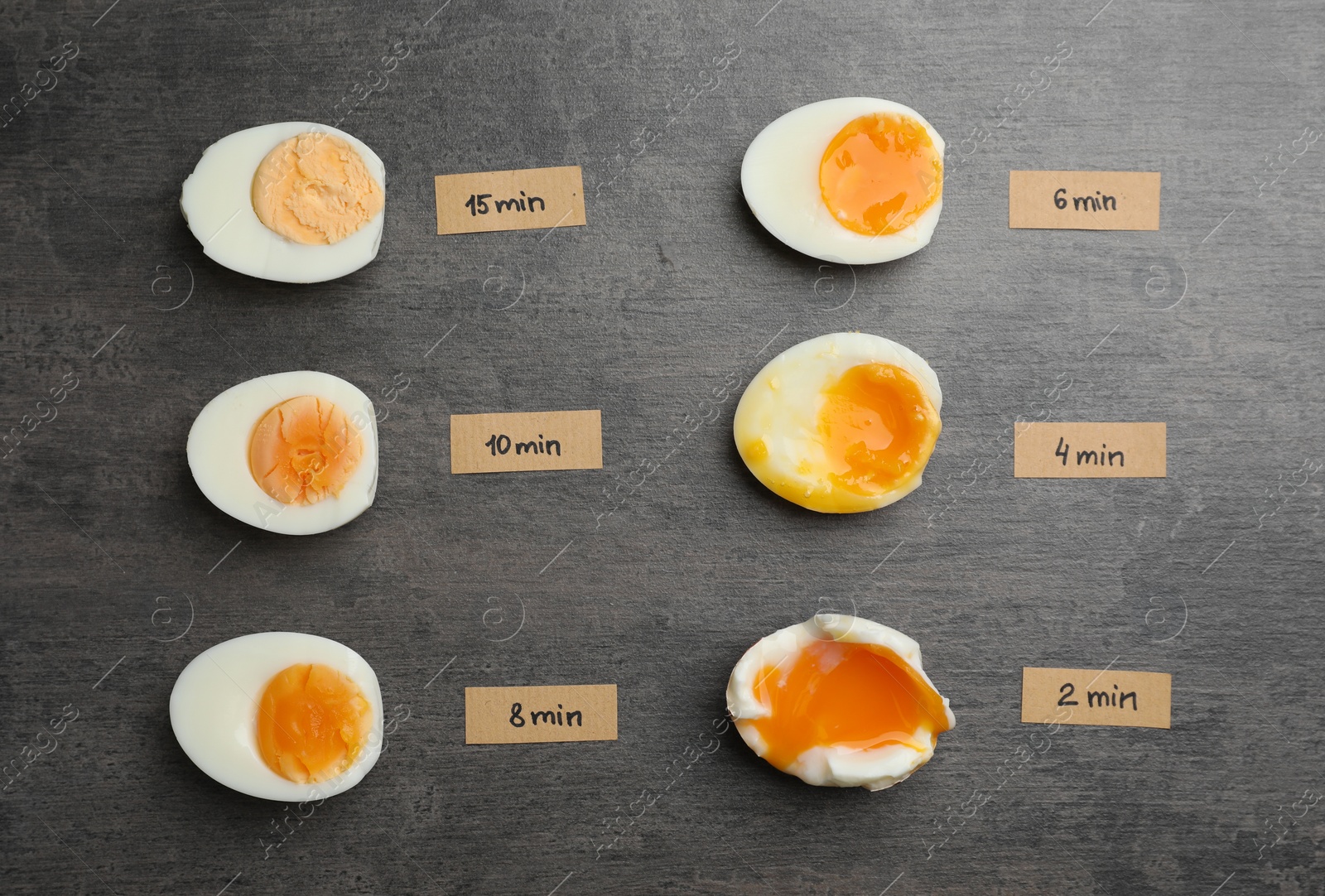 Photo of Various types of boiled eggs on grey background, flat lay. Cooking time