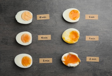 Photo of Various types of boiled eggs on grey background, flat lay. Cooking time