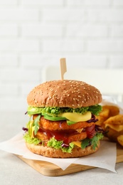 Photo of Vegan burger with carrot patties and fried potato served on table against light background. Space for text