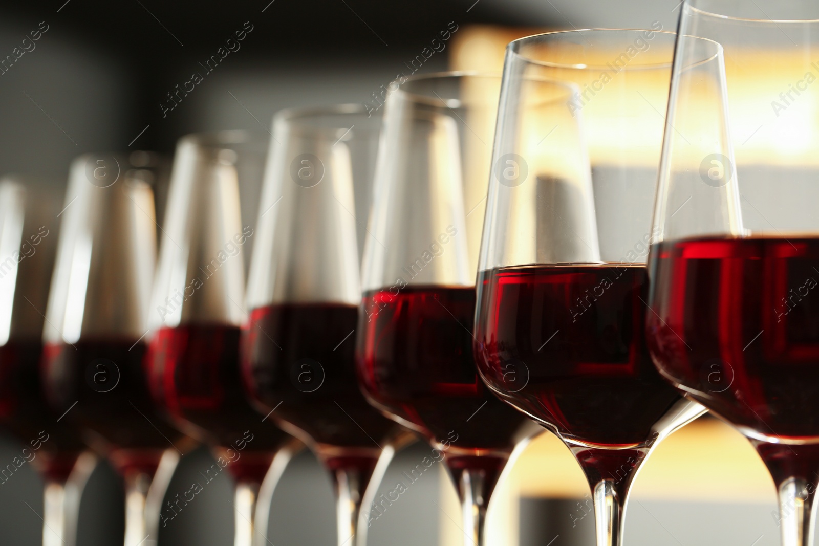 Photo of Glasses of red wine in cellar, closeup. Expensive drink