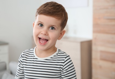 Portrait of little boy laughing at home