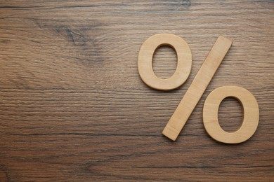 Photo of Percent sign on wooden table, flat lay. Space for text