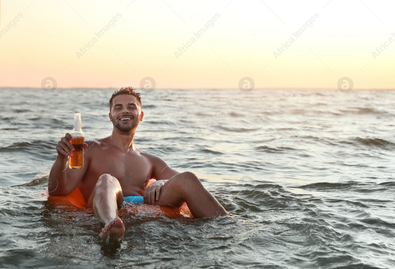 Photo of Happy young man on inflatable ring in water