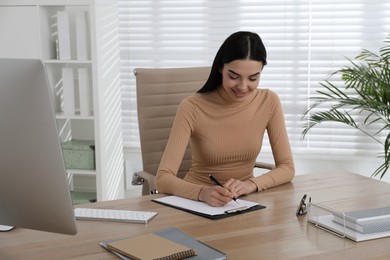 Photo of Secretary working at wooden table in office