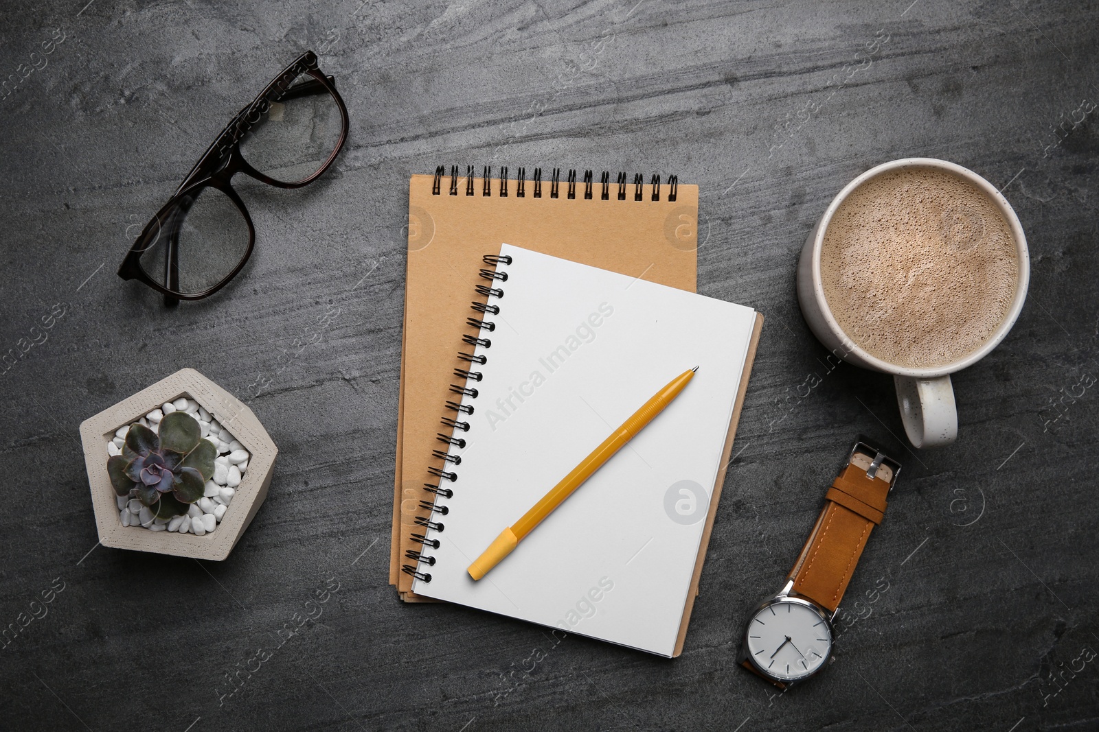 Photo of Flat lay composition with office stationery and cup of coffee on grey stone surface