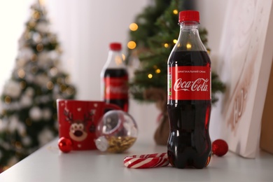 MYKOLAIV, UKRAINE - JANUARY 13, 2021: Bottle of Coca-Cola in room decorated for Christmas