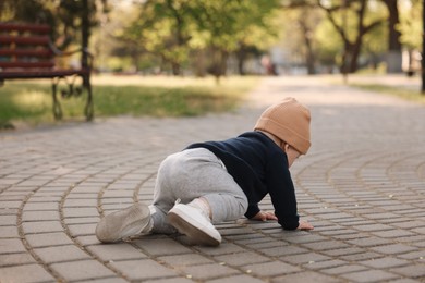 Photo of Learning to walk. Little baby crawling in park