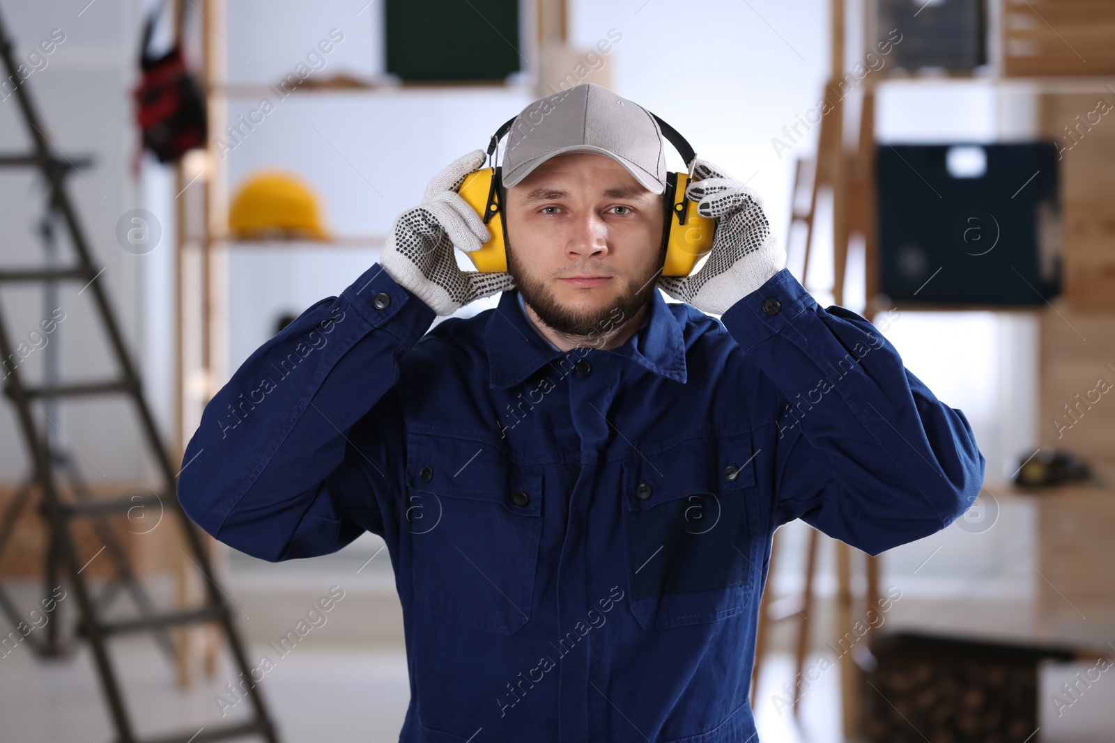 Photo of Worker wearing safety headphones indoors. Hearing protection device