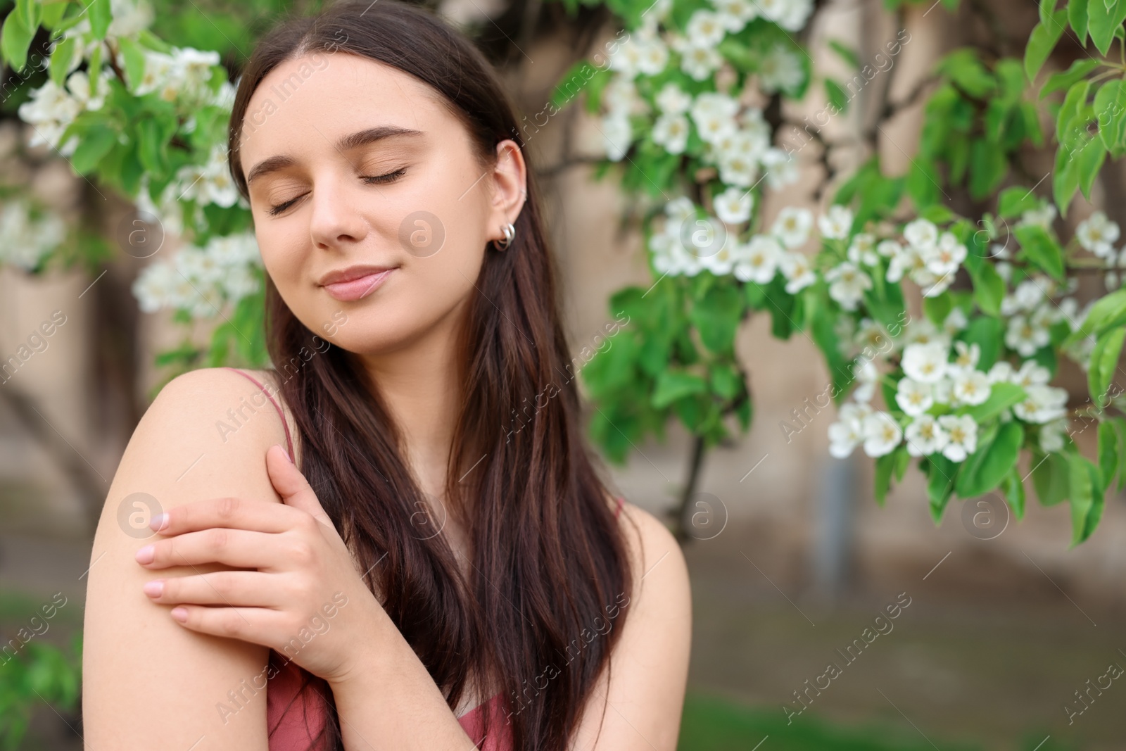 Photo of Beautiful woman near blossoming tree on spring day