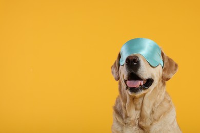 Cute Labrador Retriever with sleep mask on yellow background, space for text