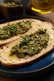 Photo of Tasty bruschettas with pesto and rosemary on plate, closeup