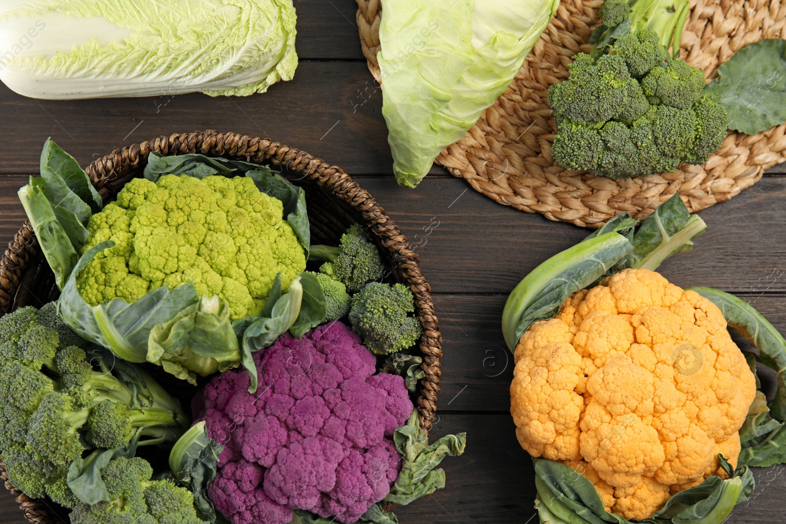 Photo of Different cabbages on wooden table, top view. Healthy food