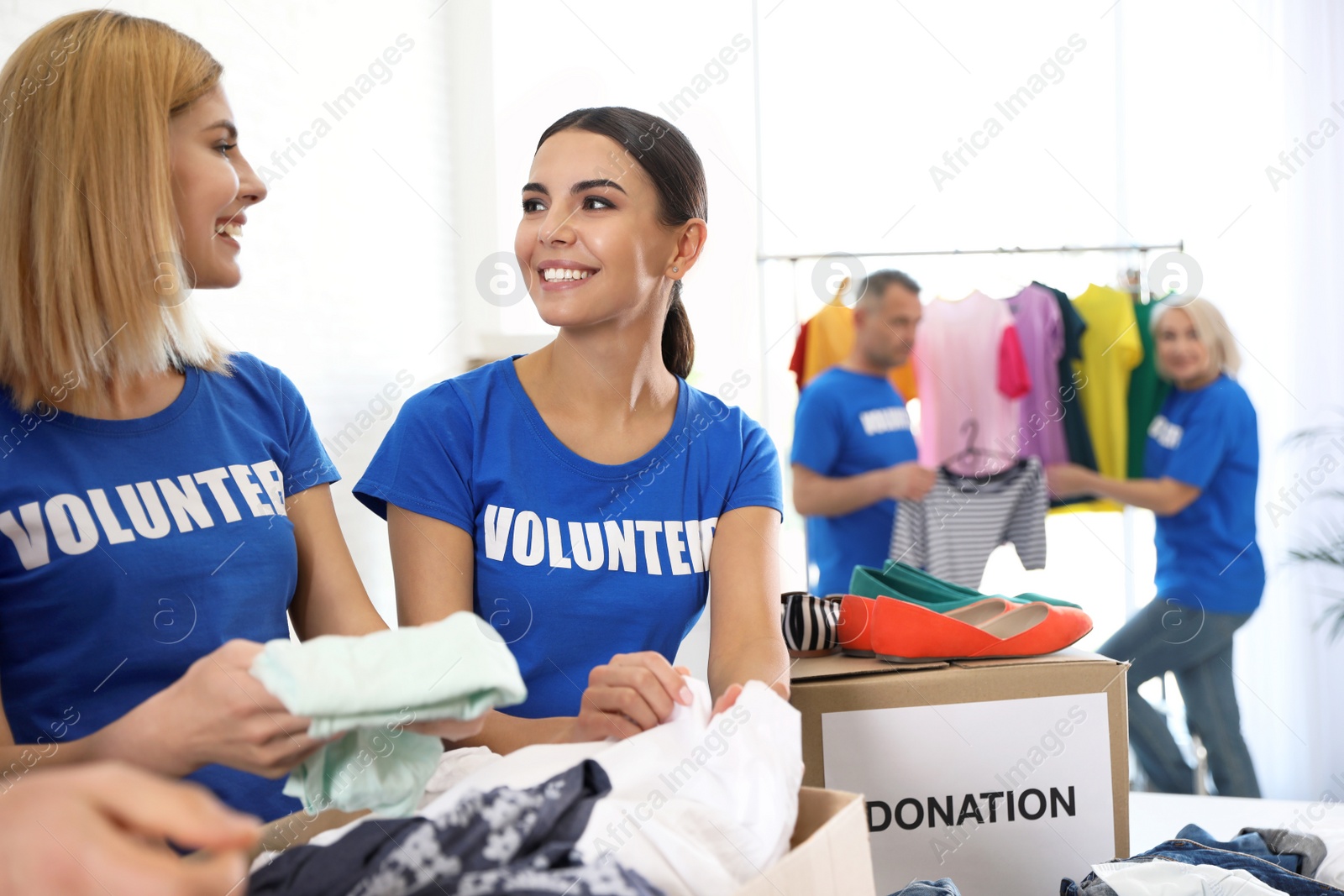 Photo of Team of volunteers collecting donations in boxes indoors