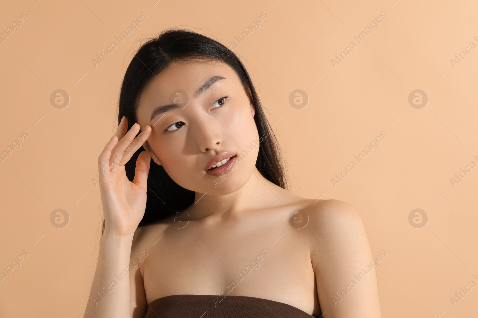 Photo of Beautiful young woman with makeup on beige background