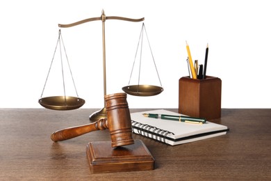 Photo of Law concept. Gavel, scales of justice, stationery on wooden table against white background