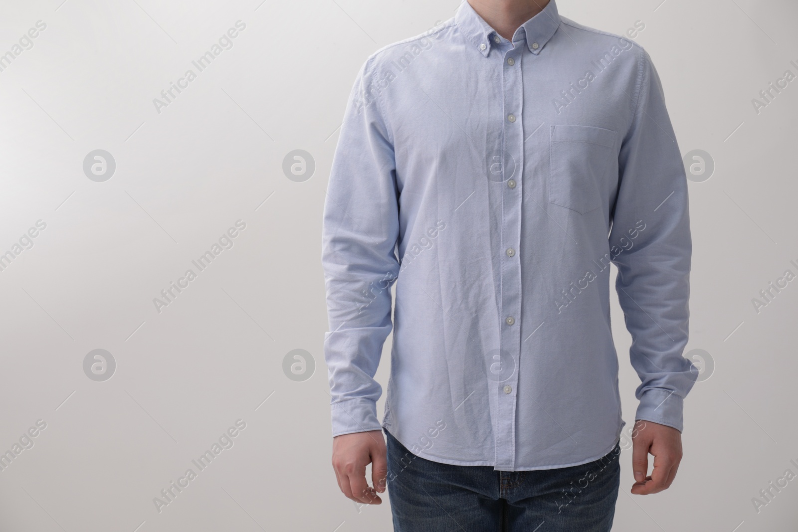 Photo of Man wearing rumpled shirt on white background, closeup