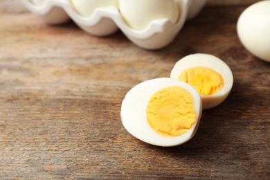 Photo of Hard boiled egg on wooden table. Space for text