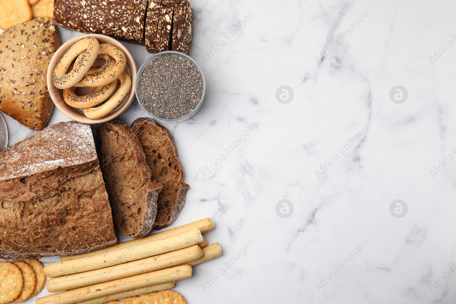 Photo of Different gluten free products on white marble table, flat lay. Space for text