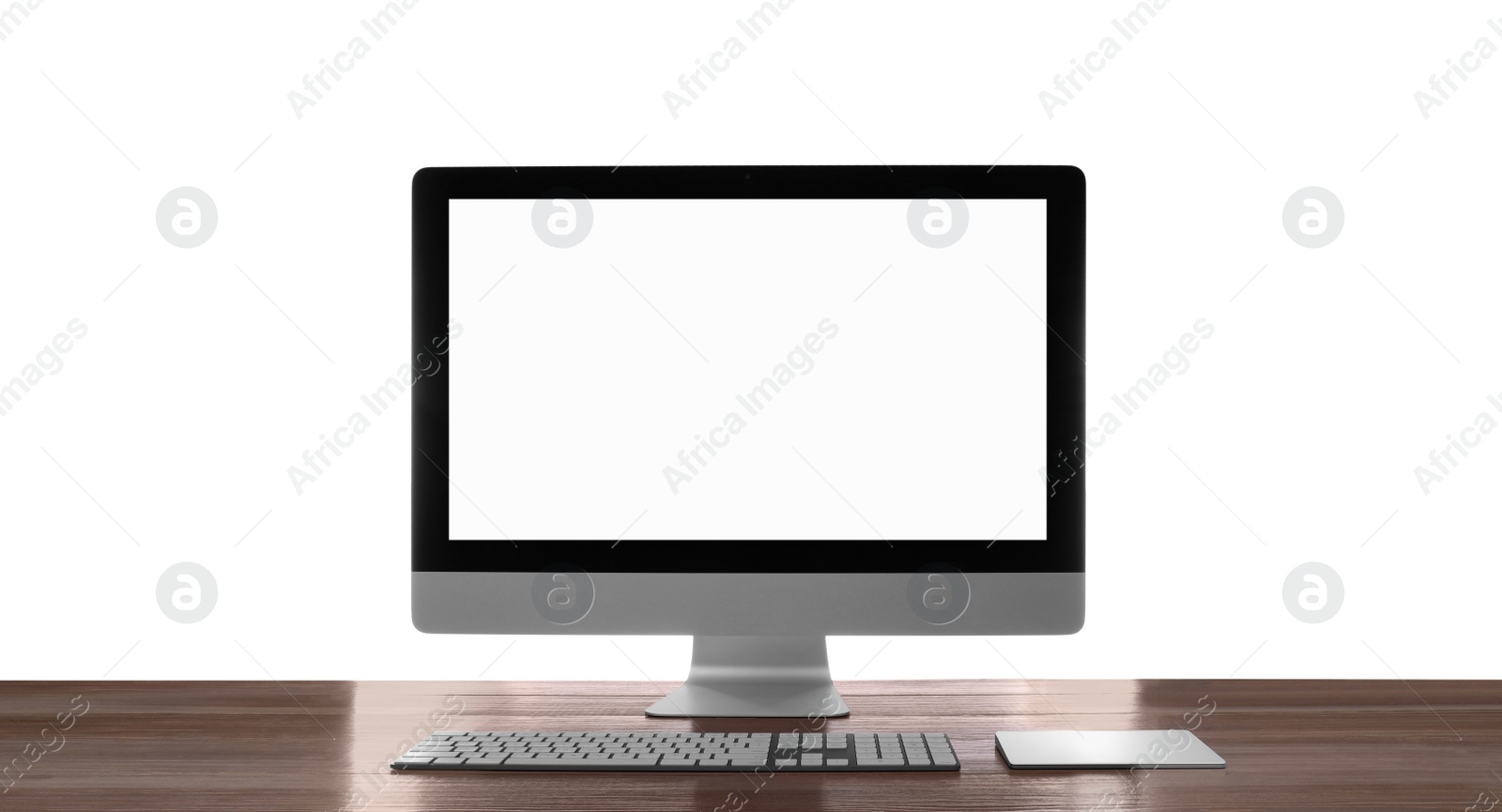 Photo of Modern computer with blank monitor screen and peripherals on wooden table against white background