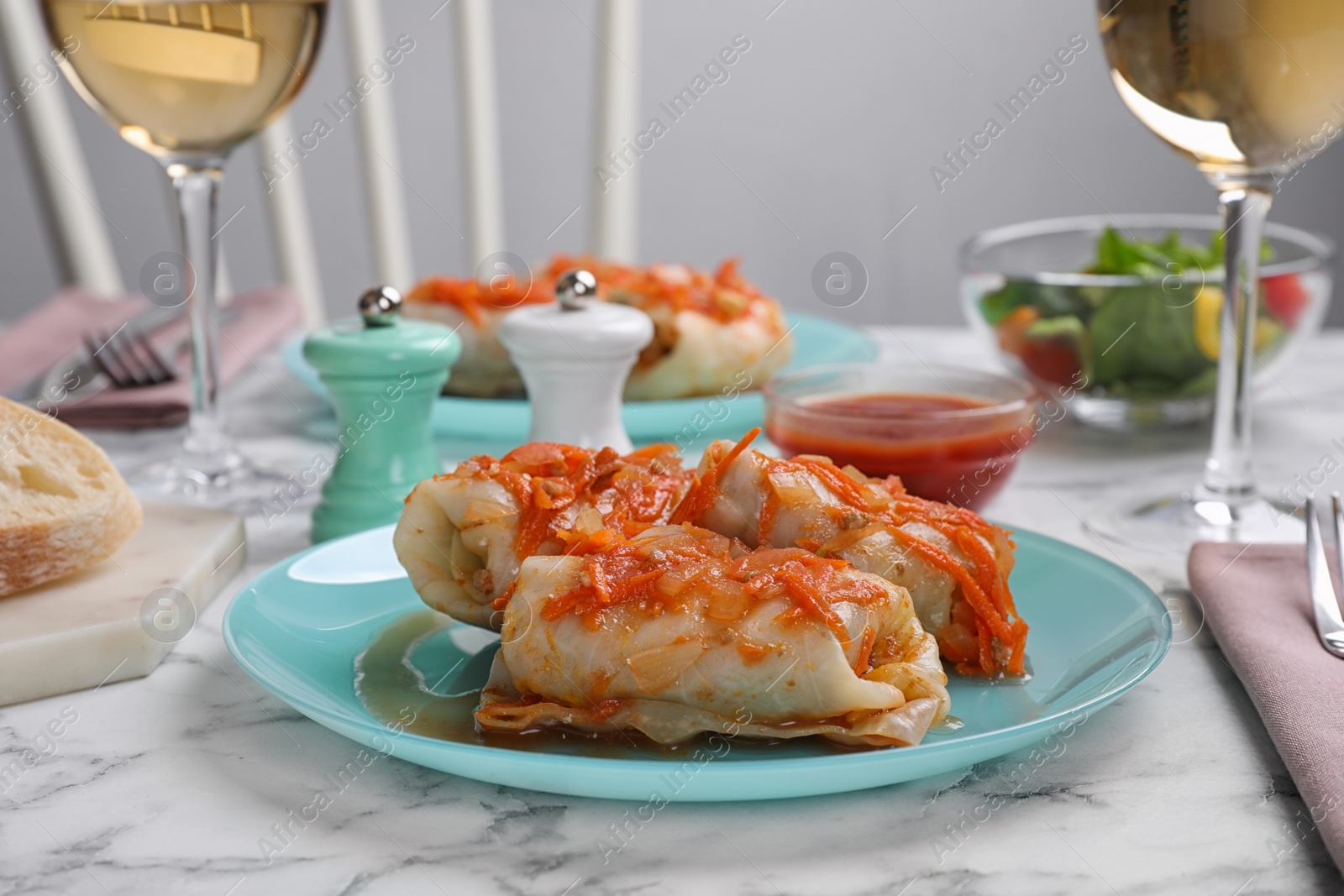 Photo of Delicious cabbage rolls served on white marble table