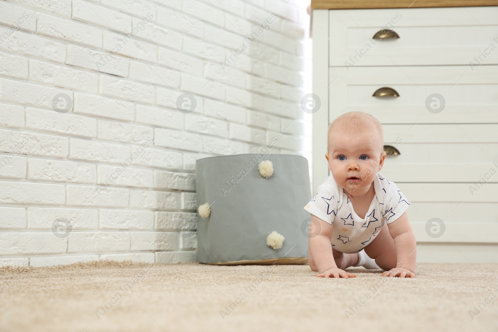 Photo of Cute little baby crawling on carpet indoors