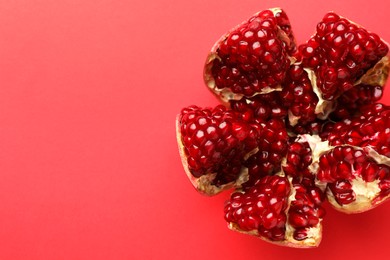 Cut fresh pomegranate on red background, top view. Space for text