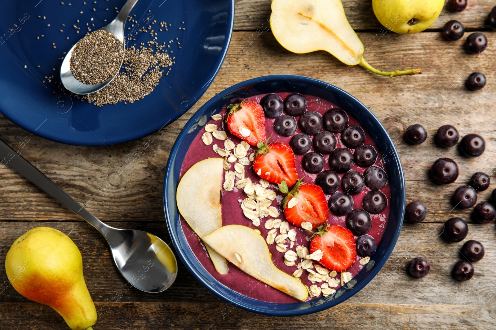 Photo of Flat lay composition with bowl of tasty acai smoothie on wooden table