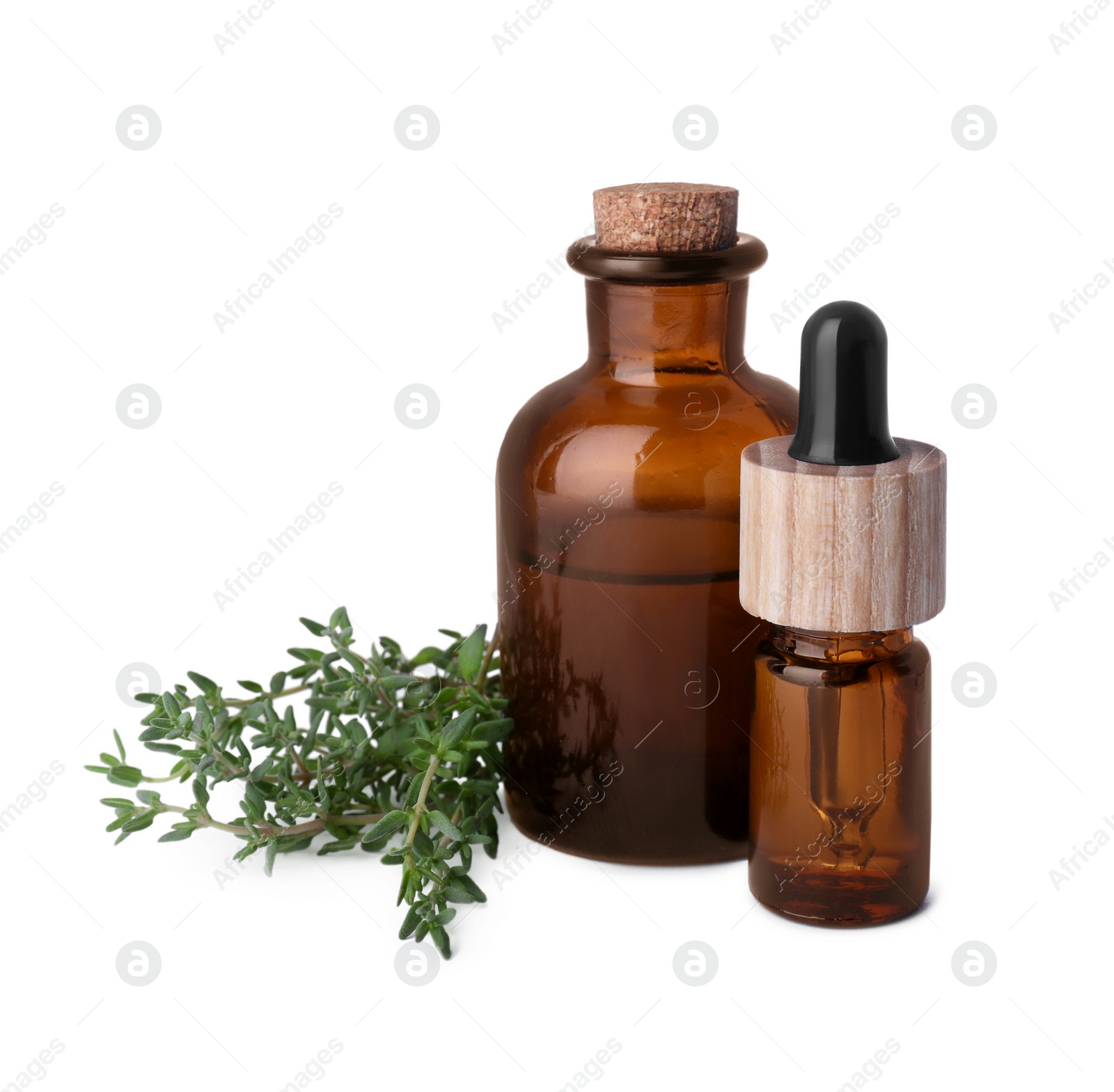 Photo of Bottles of thyme essential oil and fresh plant isolated on white