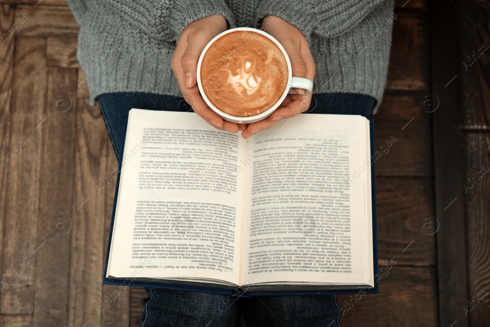 Photo of Woman with cup of coffee reading book at home, top view