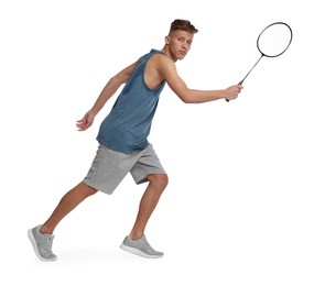 Young man playing badminton with racket on white background