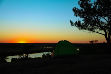 Photo of View of tent near river in evening