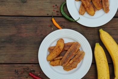Delicious fried bananas, fresh fruits and different peppers on wooden table, flat lay. Space for text