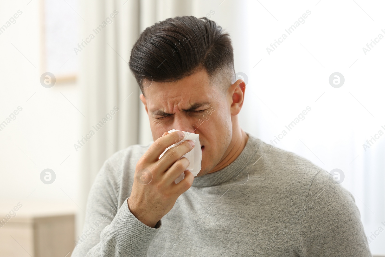 Photo of Ill man with paper tissue at home